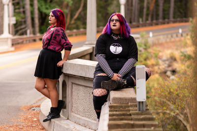 Portrait of women sitting on railing