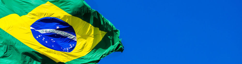 Low angle view of flag against blue sky