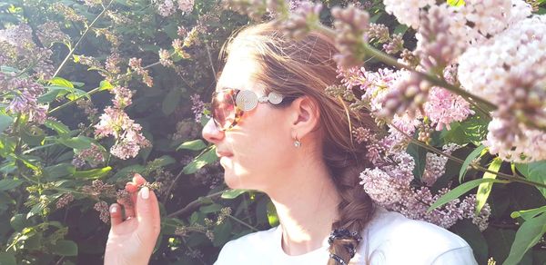 Close-up of woman wearing sunglasses against plants