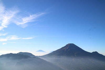 Scenic view of mountains against blue sky