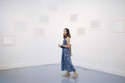 Woman standing against wall at home