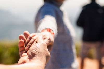 Midsection of couple holding hands