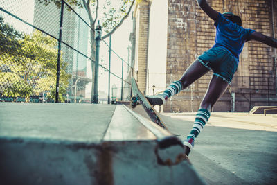 Rear view of young woman skateboarding at skateboard park