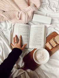 Cropped hand of woman holding coffee on table