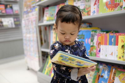 Full length of girl looking at book