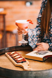 Midsection of woman with ice cream on table