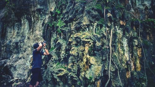 Man photographing rock formation through camera