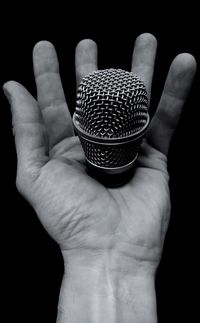 Close-up of human hand against black background