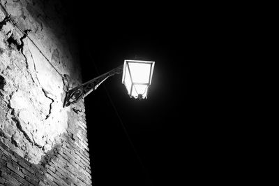 Low angle view of illuminated street light against building