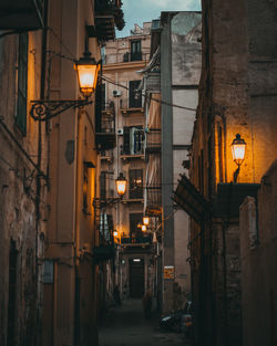 Illuminated street amidst buildings at night