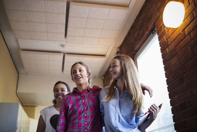 Low angle view of happy girls at school