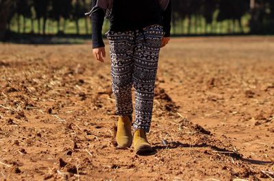 Low section of woman standing on field