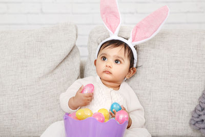 Cute girl wearing costume sitting on sofa