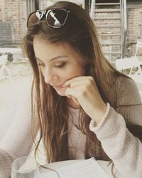 Thoughtful woman sitting at table at sidewalk cafe