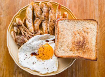 The healthy breakfast with fried egg, grilled chicken tenderloin, grilled mushroom and toast