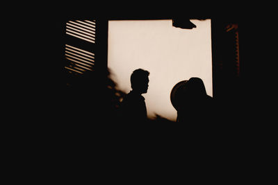 Silhouette of man and woman standing on tiled floor