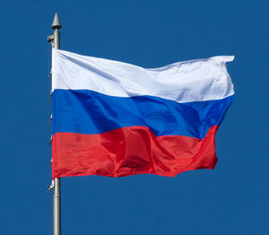 Low angle view of flag against blue sky