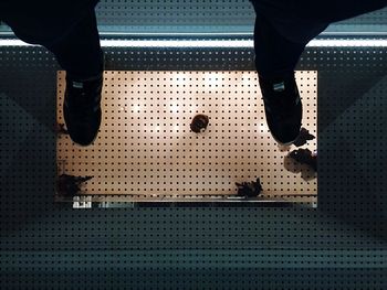 Low section of man standing on tiled floor