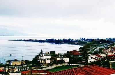 High angle view of townscape by sea against sky