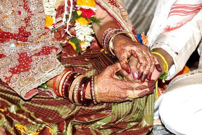 High angle view of bridegroom holding hands during rituals