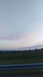 Scenic view of field against sky at sunset