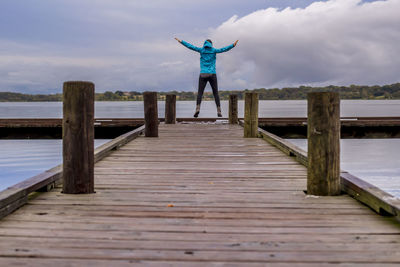 Rear view of man standing on jetty