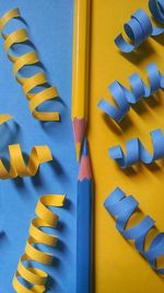 Directly above shot of colored pencils with papers on table