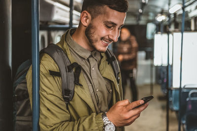 Man reading from mobile phone screen while traveling on metro. wireless internet on public transport