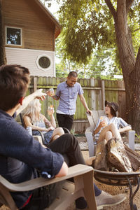 Cheerful friends having drinks in yard