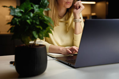 Woman at home workplace using laptop at night