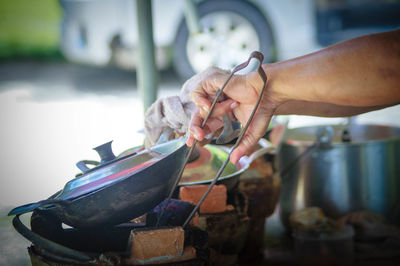 Cropped hand preparing food outdoors