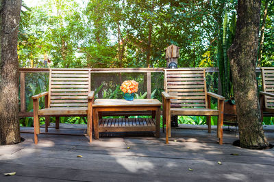 Empty bench and table against trees in park