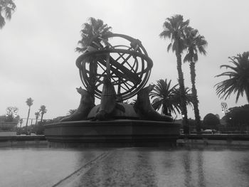 Low angle view of sculpture by swimming pool against sky