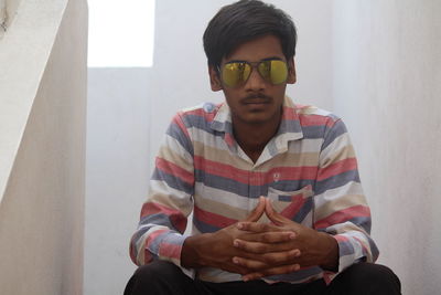 Man sitting on building terrace against sky