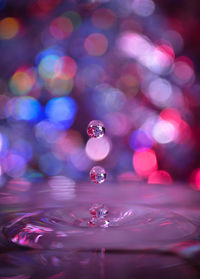 Close-up of water splashing on pink surface