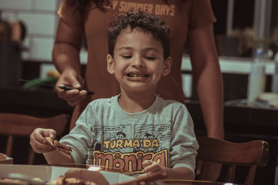 Portrait of smiling woman sitting on table