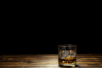 Wine glass on table against black background