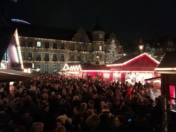 Crowd at illuminated temple against sky at night