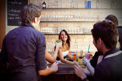 Rear view of friends sitting in restaurant