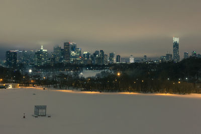 Illuminated city against sky during winter