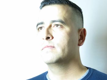 Close-up portrait of young man against white background