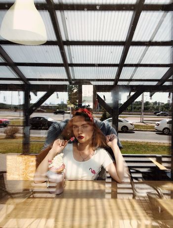 PORTRAIT OF HAPPY YOUNG WOMAN SITTING ON TABLE