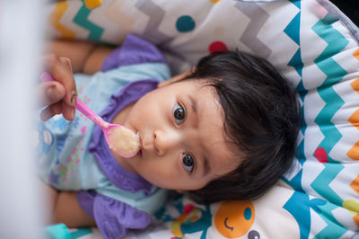 Portrait of cute baby lying on bed