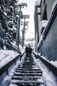 People walking on snow covered city in winter