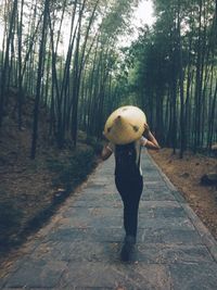 Rear view of woman walking in forest