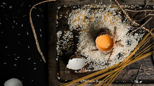 Directly above shot of broken egg and rice on cutting board