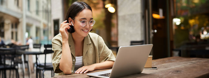 Businesswoman using laptop at table