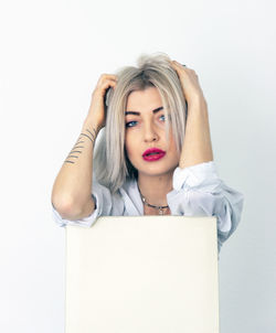 Portrait of young woman against white background