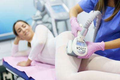 Midsection of doctor examining patient in clinic