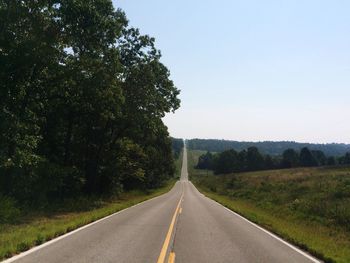 Empty road along trees